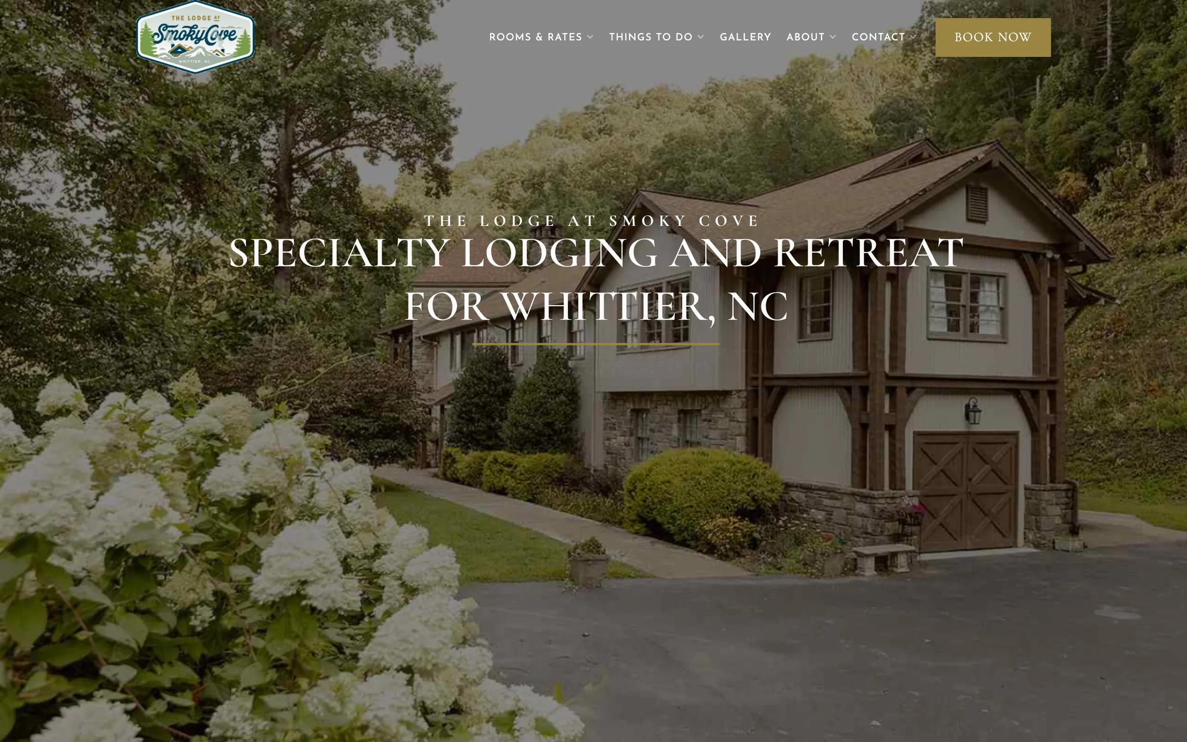 The original Smoky Cove Lodge homepage: a photograph of the lodge behind the headline Specialty Lodging and Retreat for Whittier, NC, with menus for rooms and rates, things to do, gallery, about and contact, and a Book Now button.